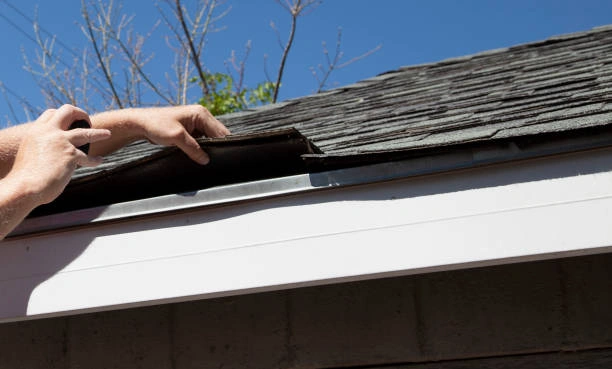 Roofing professional conducting a roof inspection on a residential home