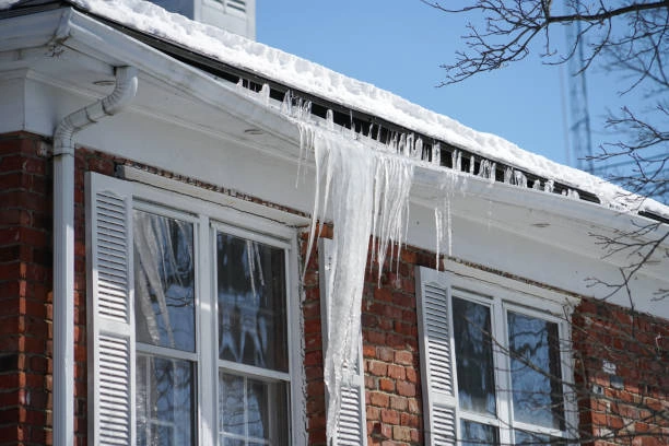 Crew using steam machine for ice dam removal on residential home