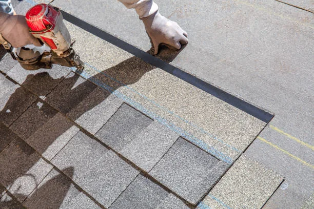 Asphalt shingles being installed during new roof installation