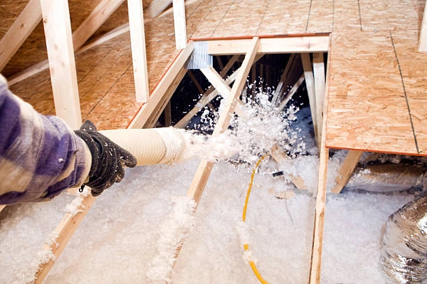 Fiberglass insulation batts installed inside wall cavities of a new home