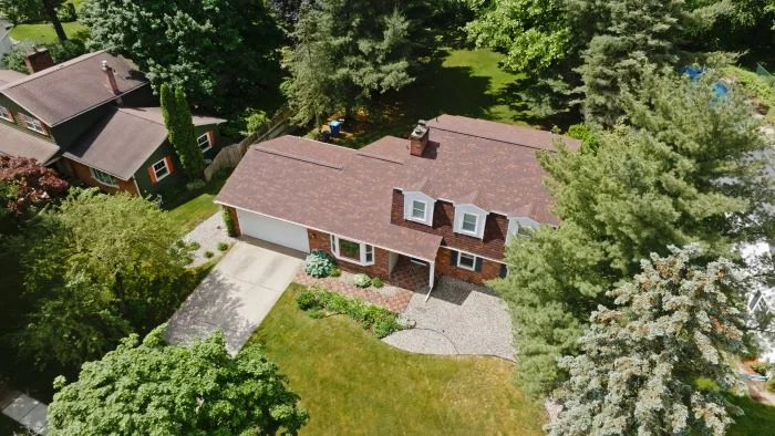 New asphalt shingle roof replacement completed on a two-story house