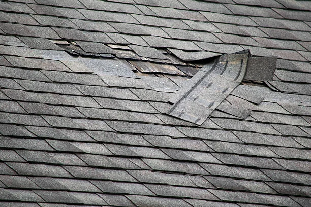 Roofer performing emergency roof repairs on a residential home