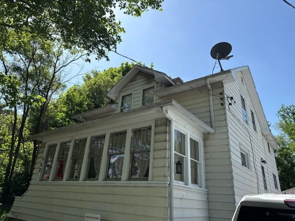 Side-by-side comparison of a flat roof and a sloped shingle roof on residential homes.