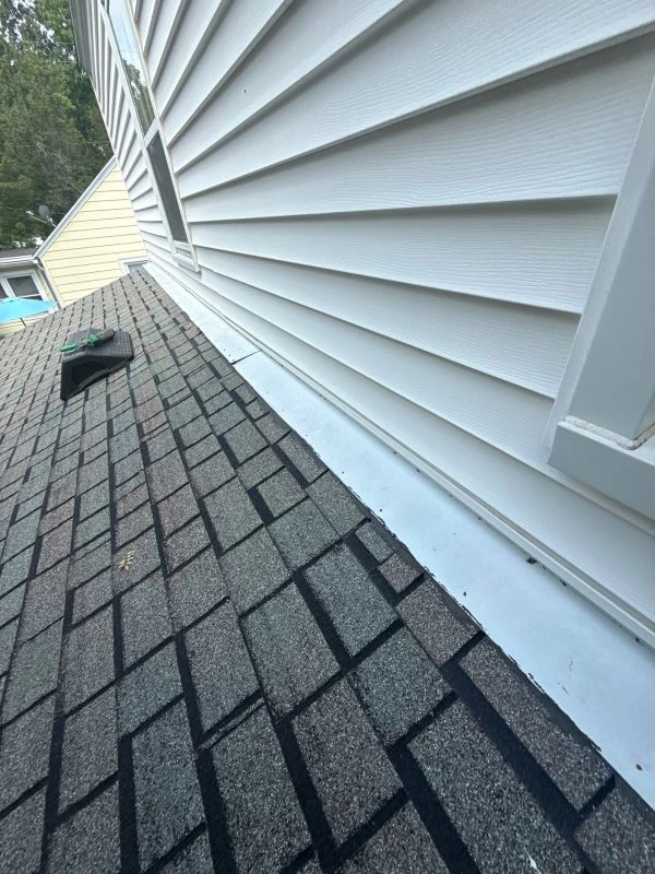 Close-up of a home’s roof and siding showing water damage, helping homeowners identify the source of a leak.