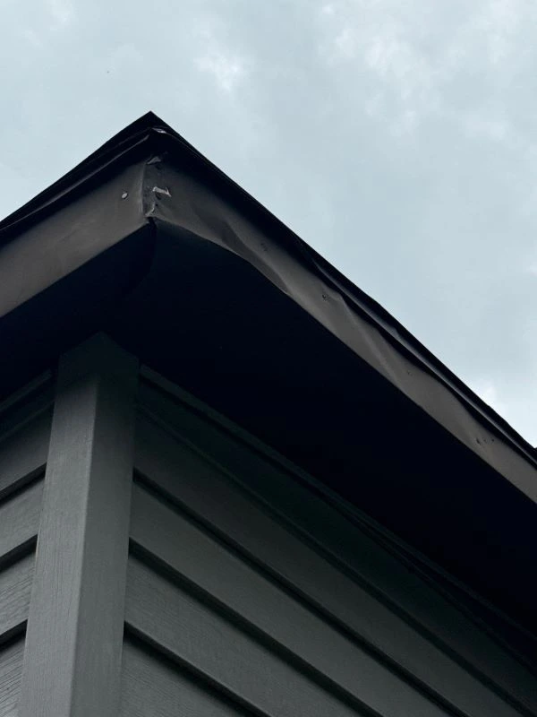 House with clean gutters directing rainwater away from siding and foundation to prevent water damage.