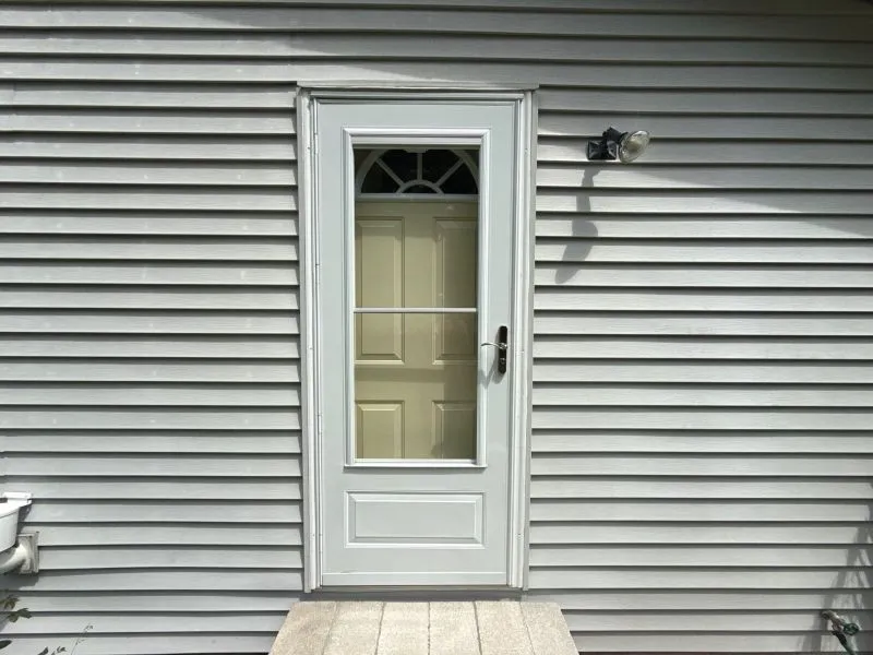 Exterior home with lower siding rots near the ground due to soil moisture, poor drainage, and repeated water splashback.
