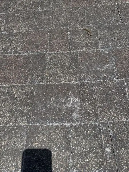 Roofer inspecting roof penetrations around vent pipes to check for flashing gaps and potential leak risks.
