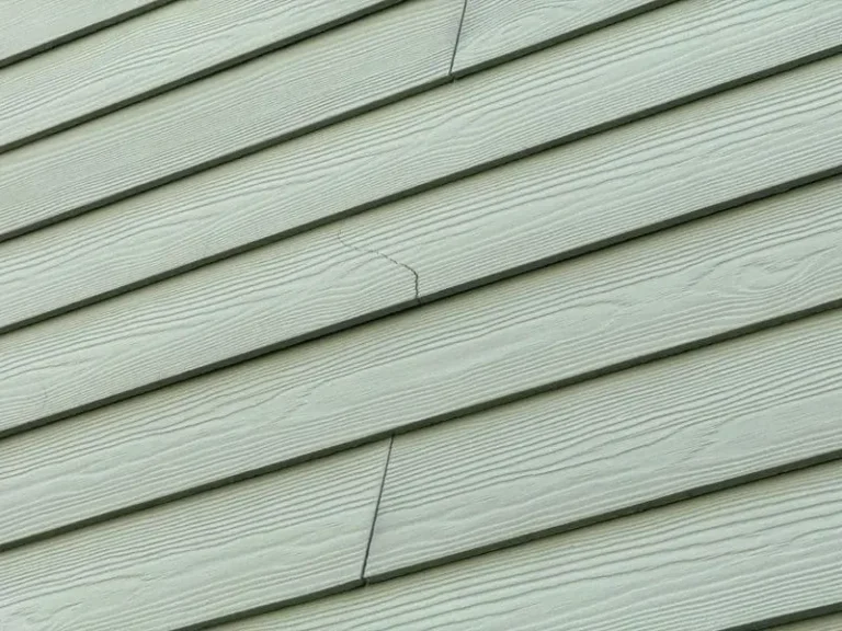 Siding corners crack on exterior home trim, showing visible damage and separation along the corner siding panel.