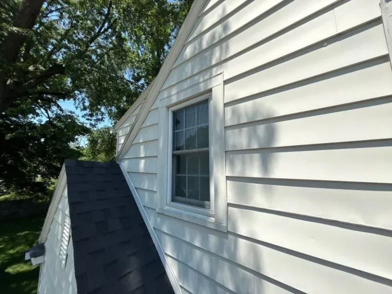 Rainwater spilling over a clean residential gutter, showing why gutters overflow despite no visible clog.