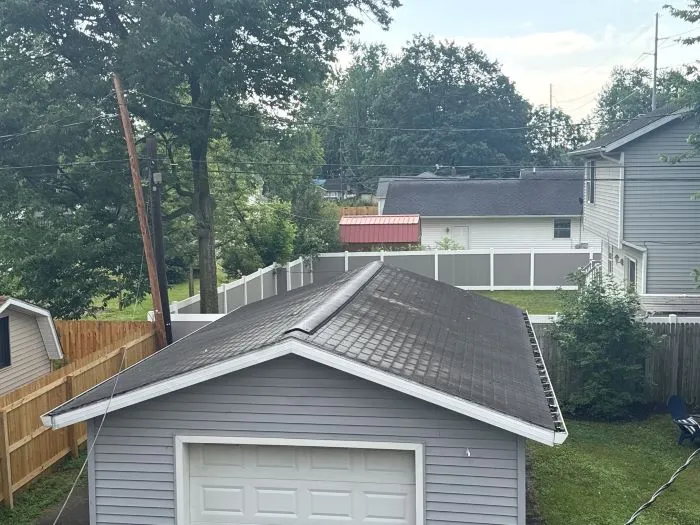 Rainwater flowing from a large roof into gutters and downspouts, showing how roof size affects drainage capacity.